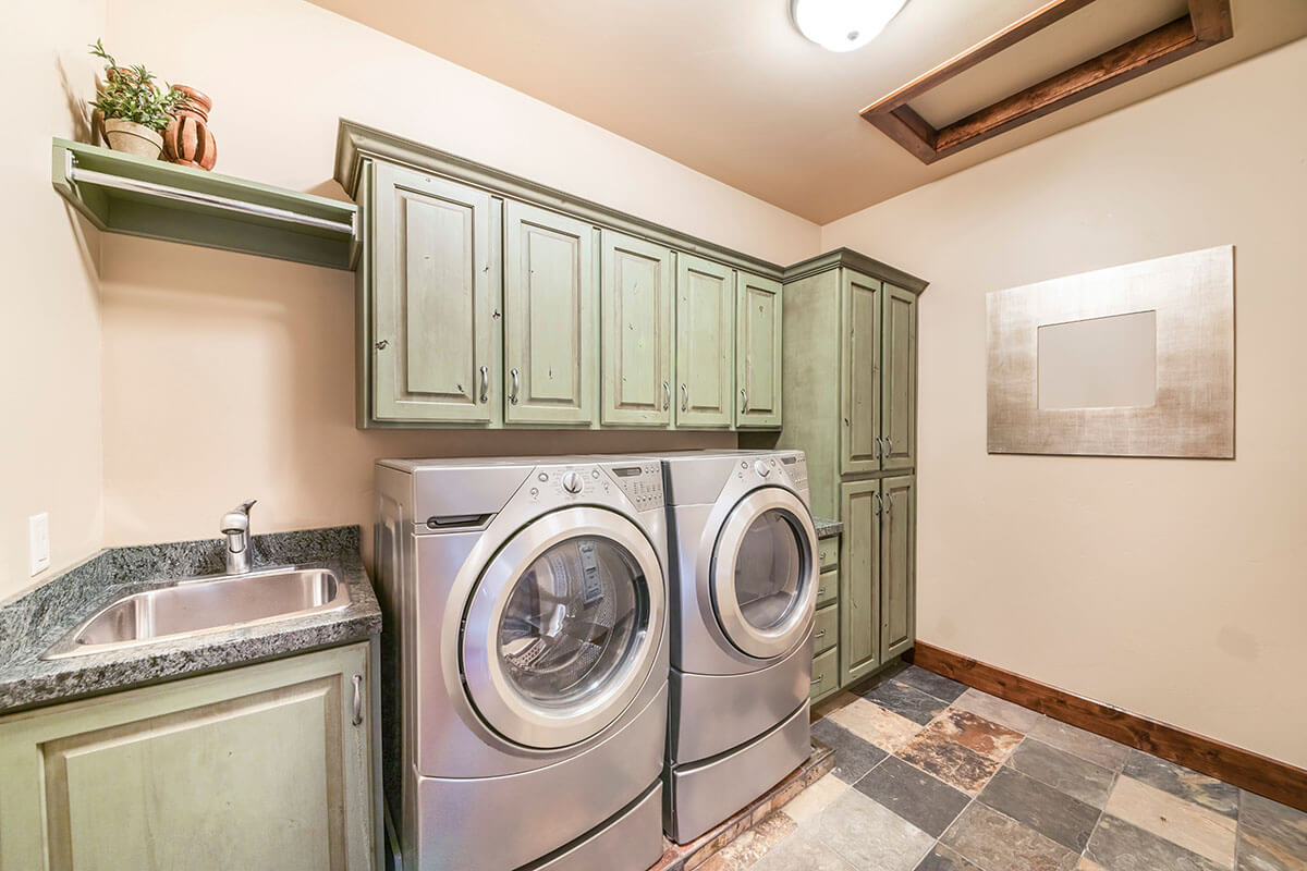 Laundry room interior with mint green cabinets
